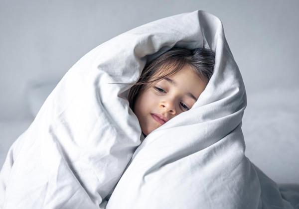 Young girl wrapped in doona